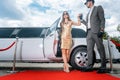 Driver helping VIP woman or star out of limo on red carpet Royalty Free Stock Photo