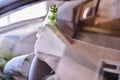 Driver holding a beer bottle and the steering wheel - drinking and driving concept Royalty Free Stock Photo