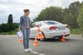 driver holding car insurance and putting traffic cones