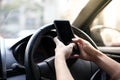 Driver holding smart phone while driving car on the road,using mobile phone texting message.People transportation dangerous Royalty Free Stock Photo