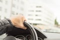 Driver holding steering wheel with one hand.