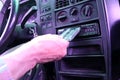 The driver inserts a cassette into a cassette recorder in an old car. Royalty Free Stock Photo