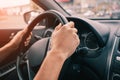 Driver keeps his hands firmly on steering wheel in his car. The concept of learning to drive and safe on the road