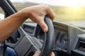 Driver keeps his hands on the steering wheel of the car.