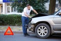 Driver man looking on wrecked car in car accident. Man regrets about fixing car after auto crash. Tragedy car collision. Dangerous Royalty Free Stock Photo