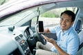 Driver online taxi in the car showing smartphone