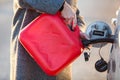 Driver pouring diesel from red plastic oil can into car tank, closeup view Royalty Free Stock Photo