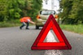 Driver in reflective vest changing tire Royalty Free Stock Photo