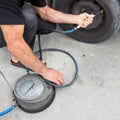 Driver at repair service station checking tyre pressure with gauge. Royalty Free Stock Photo