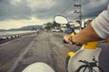 Driver riding motorcycle on an asphalt empty road near sea. Royalty Free Stock Photo