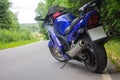 Driver riding motorcycle on an asphalt road through forest. Royalty Free Stock Photo