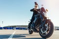 Driver riding motorcycle on empty parking at airport at beautiful autumn time. Royalty Free Stock Photo