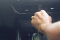 Driver`s hand holding automatic gear stick to shift the gear while sitting in the car driver`s seat and driving luxurious super Royalty Free Stock Photo