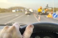 Driver`s hand on the steering wheel of a car that passes through the repaired section of the road Royalty Free Stock Photo