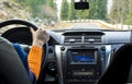 Driver`s hand on the steering wheel inside a car on a mountain road Royalty Free Stock Photo