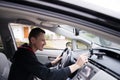 Driver sets GPS navigator sitting behind the wheel Royalty Free Stock Photo
