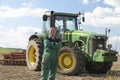 Driver Standing In Front Of Tractor