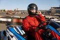 Driver taking off protective helmet while sitting at kart race car Royalty Free Stock Photo