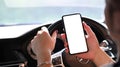 Driver using smart phone for communication while driving car. Royalty Free Stock Photo