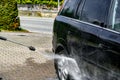 The driver washes the car wheels with high pressure water