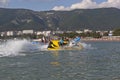 Driver a water motorcycle lays the steep turn and sprinkles water of passengers inflatable banana. Gelendzhik