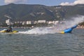 Driver a water motorcycle water splashes of passengers inflatable banana. Beach activities in Gelendzhik Bay