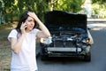 Driver woman in front of wrecked car in car accident. Scared woman in stress holding her head after auto crash calling to auto Royalty Free Stock Photo