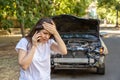 Driver woman portrait in front of wrecked car in car accident. Scared woman in stress holding her head after auto crash calling to Royalty Free Stock Photo