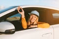 Driver woman traveling by rental car showing keys in open window. Road trip vacations Royalty Free Stock Photo