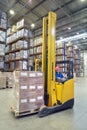 Driver of yellow forklift truck operates, in warehouses.