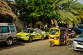 Drivers of yellow tuk tuks ply their trade around the port city