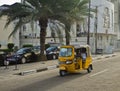 Drivers of yellow tuk tuks ply their trade around the port city