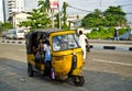 Drivers of yellow tuk tuks ply their trade around the port city