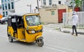 Drivers of yellow tuk tuks ply their trade around the port city