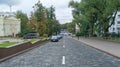 The driveway of the city street, where cars are parked, is paved with treated stone and the sidewalks with concrete tiles. Along t Royalty Free Stock Photo