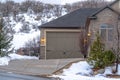 Driveway and garage entrance of home against snowy hill landscape in winter Royalty Free Stock Photo