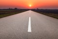 Driving on asphalt road towards the setting sun Royalty Free Stock Photo