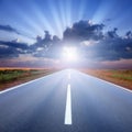 Driving on asphalt road towards the sunbeams Royalty Free Stock Photo