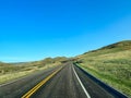 Driving through the badlands hills and mountains with Wild Horses standing in the road in Theodore Roosevelt National Park in Royalty Free Stock Photo