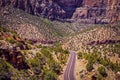 Driving through Badlands - Zion National Park - Utah USA - two land highway through shrub and trees and towering rocky cliffs Royalty Free Stock Photo