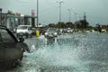 Driving car on flooded road during flood caused by torrential rains. Cars float on water, flooding streets. Splash on the car.