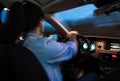 Young man driving his modern car at night in a city Royalty Free Stock Photo