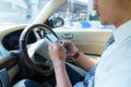 Driving car and using phone. Distracted driver texting with mobile cellphone. Irresponsible man checking message with smartphone Royalty Free Stock Photo