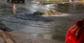 Driving cars on a flooded road during floods caused by rain storms. Cars float on water, flooding streets. Splash on the machine.