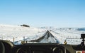 Driving on the country road in winter. Looking through car front windscreen, frozen road with snow covered and clear blue sky in I Royalty Free Stock Photo