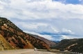 Driving curved road through the mountians with beautiful blue cloudy sky and tunnel in the distance