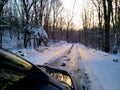 Driving down icy rural forest road in winter New England at dawn going to work Royalty Free Stock Photo