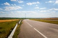 Driving on an empty asphalt road through the agricultural fields towards the setting sun. Royalty Free Stock Photo