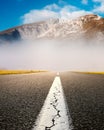 Driving on an empty asphalt road at the misty mountains Royalty Free Stock Photo