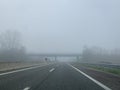 Driving on a empty highway in thick fog. Royalty Free Stock Photo